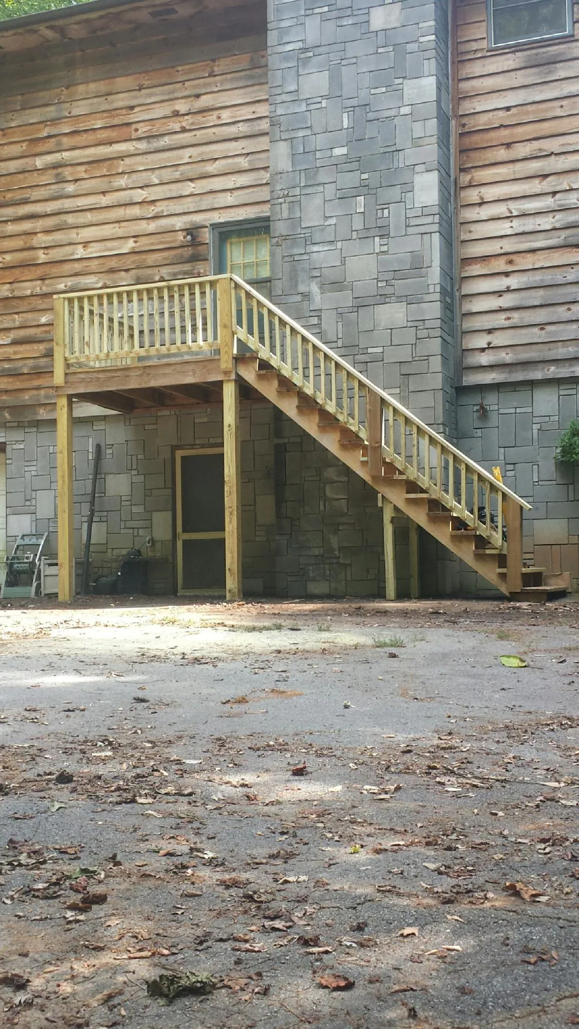 New pressure treated deck and stair landing on a log home in Hampstead