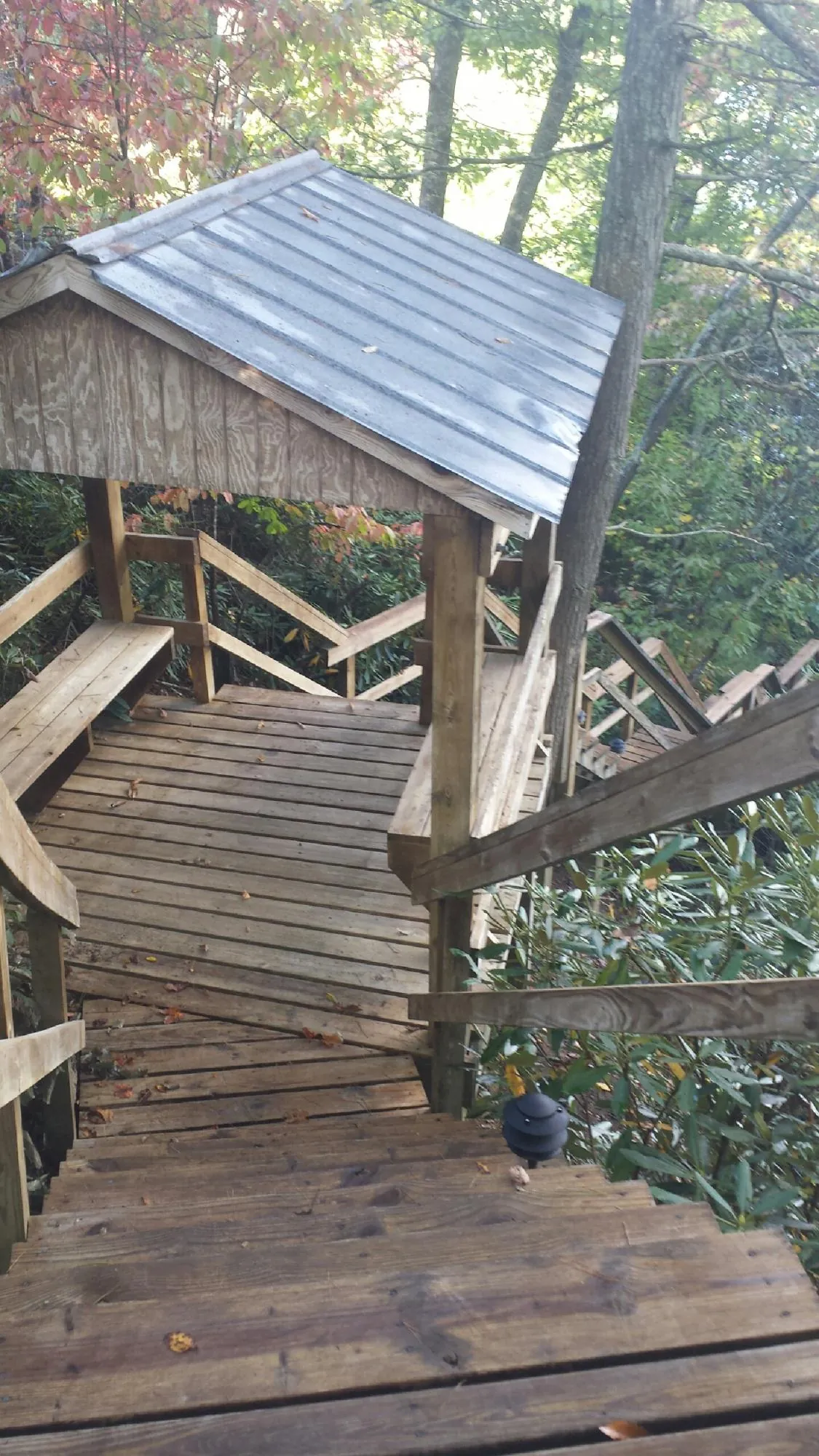 Metal roofed shelter over wooden steps on a wooded walkway — Skylight Repair & Installation work by our crew in Hampstead