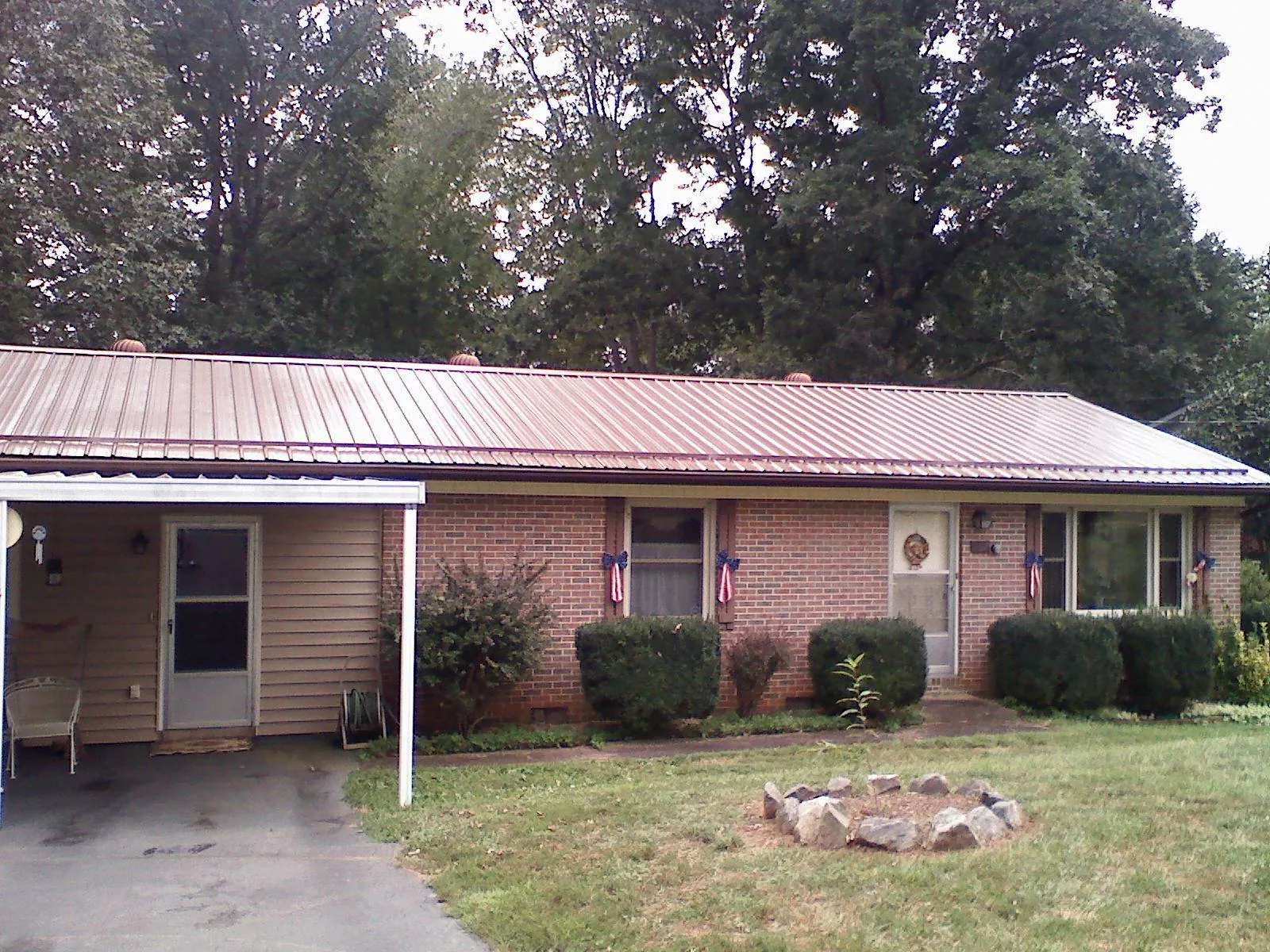 Bronze metal roof and carport on a brick ranch home — Roof Repair work by our crew in Hampstead